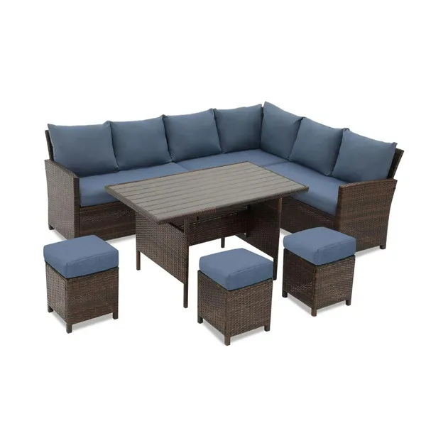 7-piece wicker patio dining set with blue cushions, ottomans, and dining table arranged in a backyard garden — perfect for family entertaining